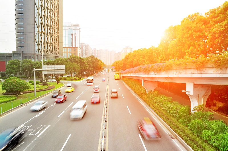 Carretera de ciudad con coches circulando a bastante velocidad