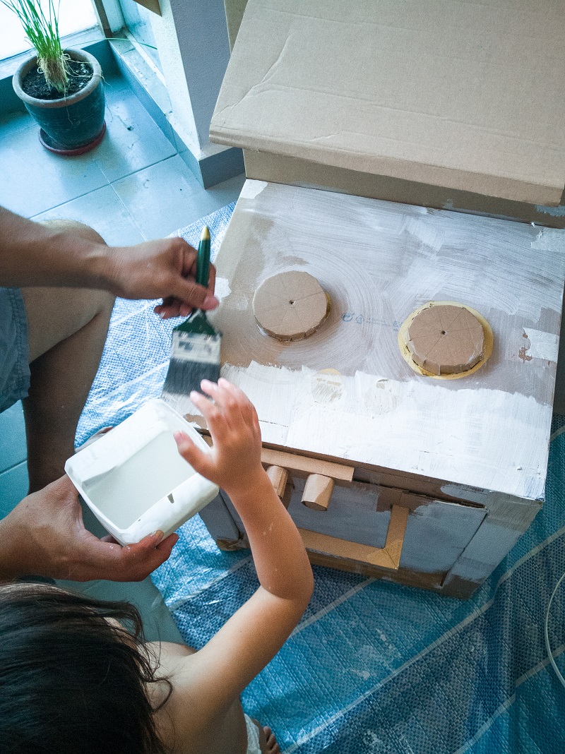 Padre e hijo fabricando una cocina de juguete con fogones de gas natural