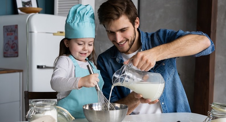 Padre e hija cocinando en la cocina un bizcocho